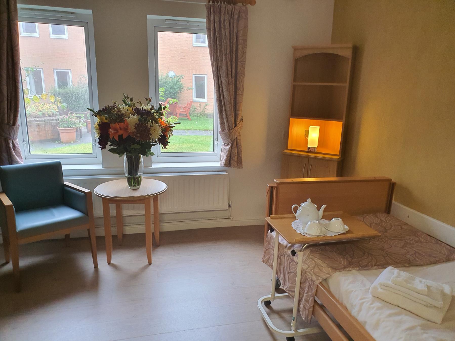 bedroom with colourful flowers on a table by the window