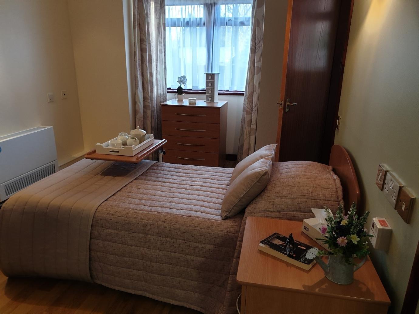 bedroom with a door open and a tray over the bed